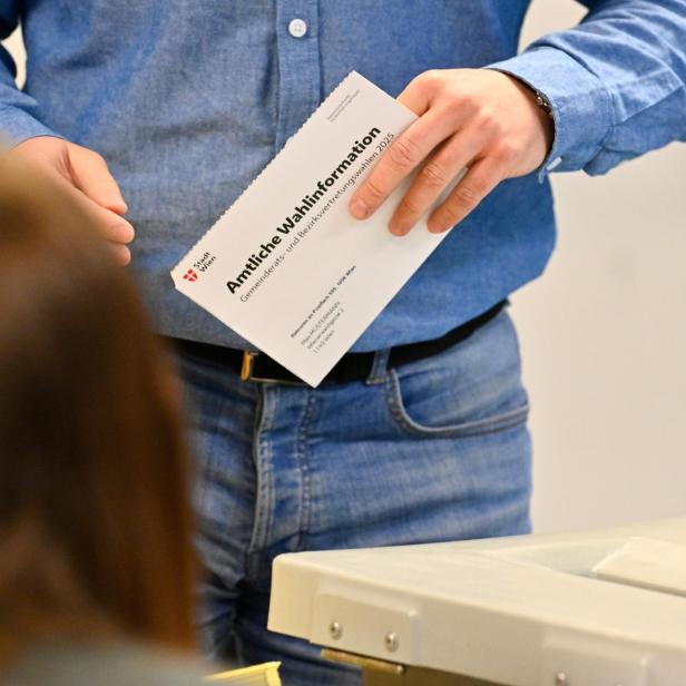 Ein Mann, der seine Wahlkarte in der Hand hält